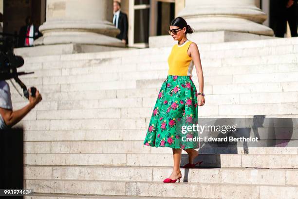 Giovanna Battaglia wears a yellow sleeveless top, a green flower print skirt, a bag, pink shoes, outside Fendi, during Paris Fashion Week Haute...