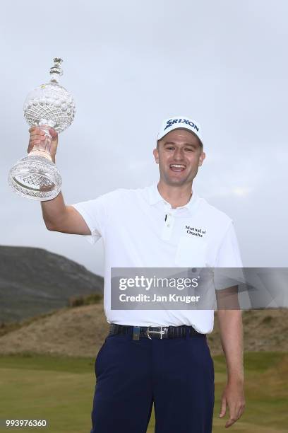 Russell Knox of Scotland celebrates with the trophy following his victory on the 18th green during a playoff at the end of the final round of the...