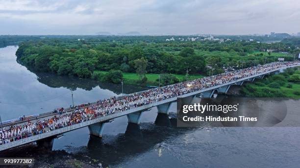 Huge procession of devotees also known as Vaarkaris cross Sangamwadi bridge as they walk towards Pandharpur to celebrate Ashadhi Ekadashi on July 7,...
