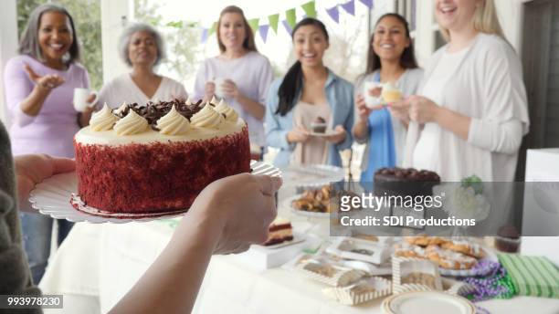 group of friends happily receiving cake at a charity party - bake sale stock pictures, royalty-free photos & images