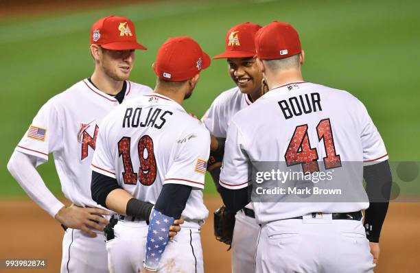 Riddle, Miguel Rojas, Starlin Castro, and Justin Bour of the Miami Marlins gather at the pitchers mound during a break in action against the Tampa...