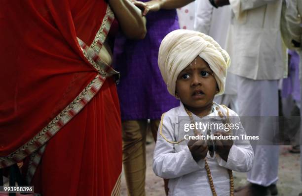 Kid devotee playing clash cymbals during annual pilgrimage called the Wari from Dnyaneshwar's shrine in Alandi to the Vitthala temple in Pandharpur...