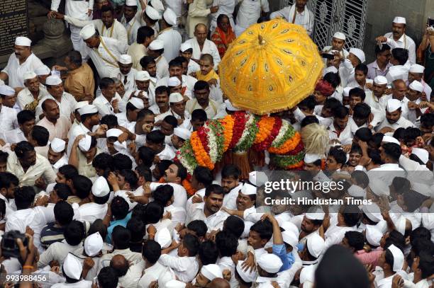 Devotees also known as warkaris carry Palkhi during annual pilgrimage called the Wari from Dnyaneshwar's shrine in Alandi to the Vitthala temple in...
