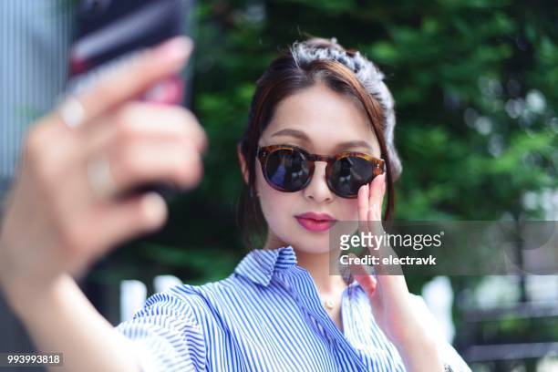 young woman taking selfie outside - vanity stock pictures, royalty-free photos & images