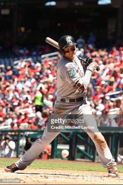 Derek Dietrich of the Miami Marlins reacts after getting hit by the pitch in the second inning during a baseball game against the Washington...