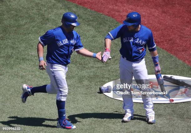 Kendrys Morales of the Toronto Blue Jays is congratulated by Russell Martin after hitting a solo home run in the sixth inning during MLB game action...