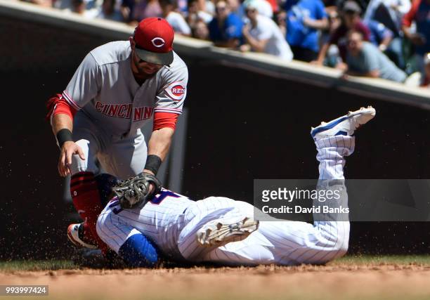 Jose Peraza of the Cincinnati Reds tags out Willson Contreras of the Chicago Cubs at second base during the third inning on July 8, 2018 at Wrigley...