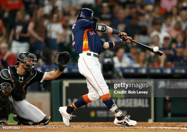 Josh Reddick of the Houston Astros lines out to right field in the fourth inning as Kevan Smith of the Chicago White Sox looks on at Minute Maid Park...