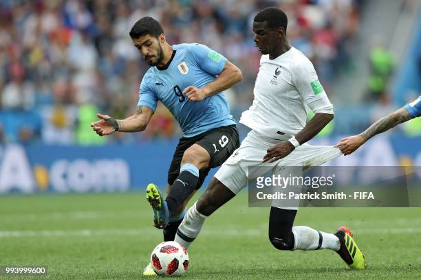 Paul Pogba of France is challenged by Lucas Torreira and Luis Suarez of Uruguay during the 2018 FIFA World Cup Russia Quarter Final match between...
