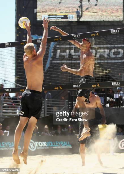 Chaim Schalk spikes the ball aorund Chase Budinger during the semifinals at the AVP San Francisco Open at Pier 30-32 on July 8, 2018 in San...