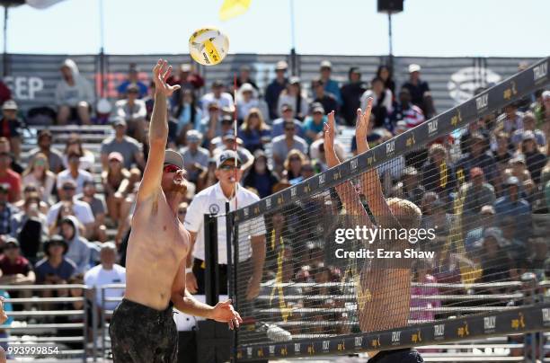 Chaim Schalk spikes the ball aorund Chase Budinger during the semifinals at the AVP San Francisco Open at Pier 30-32 on July 8, 2018 in San...