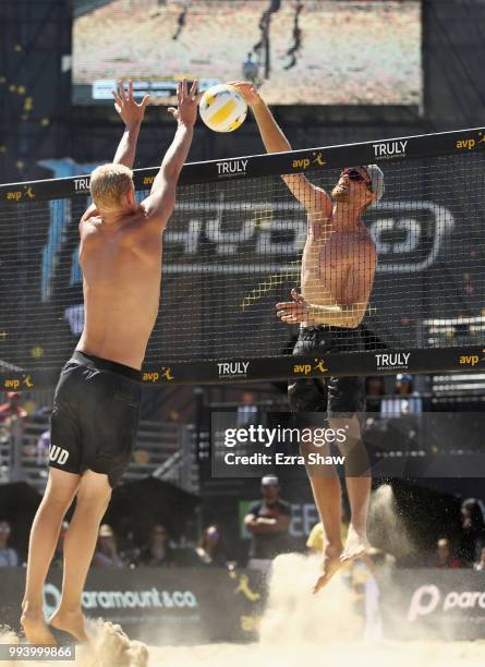 Chaim Schalk spikes the ball aorund Chase Budinger during the semifinals at the AVP San Francisco Open at Pier 30-32 on July 8, 2018 in San...