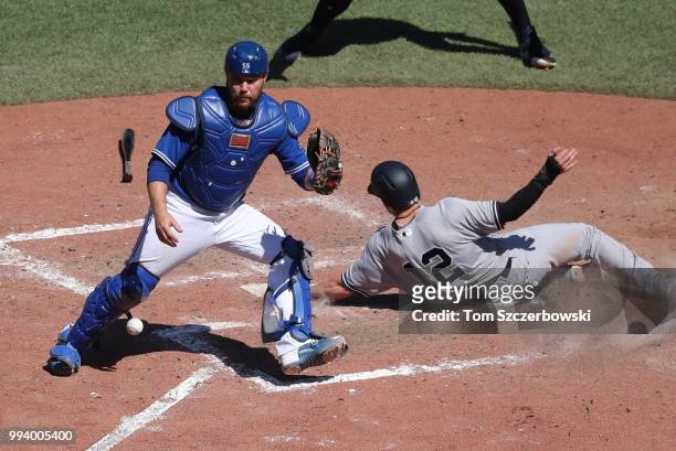 Tyler Wade of the New York Yankees scores the go-ahead run in the tenth inning during MLB game action as Russell Martin of the Toronto Blue Jays...
