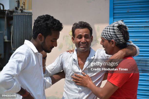 Family members and relatives of the victims seen at the spot where three men drowned in a sewage pumping station at Loni on July 8, 2018 in...