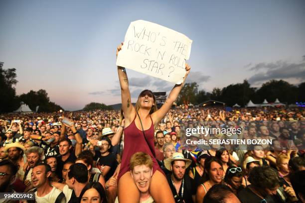 Woman holds a placard reading "Who's the rock'n roll star?" during a concert of British singer Liam Gallagher at the 30th Eurockeennes rock music...