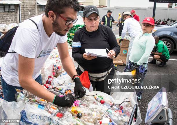 People weigh plastic bottles as they help collect 25 tons of them for recycling, in eight hours, in order to set a Guinness World Record, in San Jose...