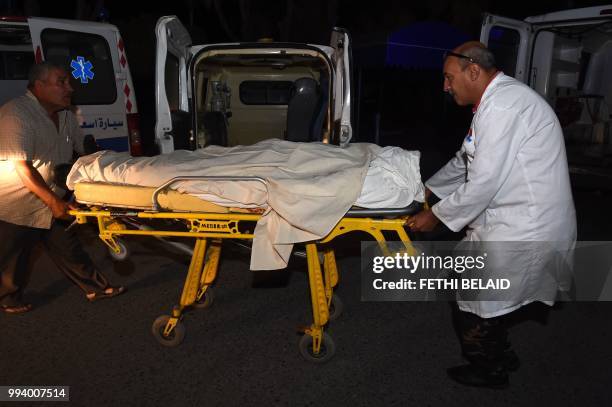 Graphic content / Hospital personnel transport the body of a Tunisian member of the security forces, who according to the country's interior ministry...