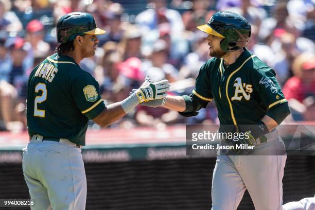Khris Davis celebrates with Jed Lowrie of the Oakland Athletics after Lowrie scored on a solo home run during the seventh inning against the...
