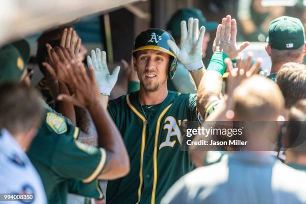 Stephen Piscotty of the Oakland Athletics celebrates in the dugout after hitting a two run home run during the sixth inning against the Cleveland...