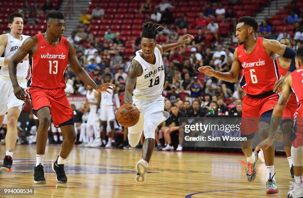 Lonnie Walker IV of the San Antonio Spurs dribbles against Thomas Bryant and Troy Brown Jr. #6 of the Washington Wizards during the 2018 NBA Summer...
