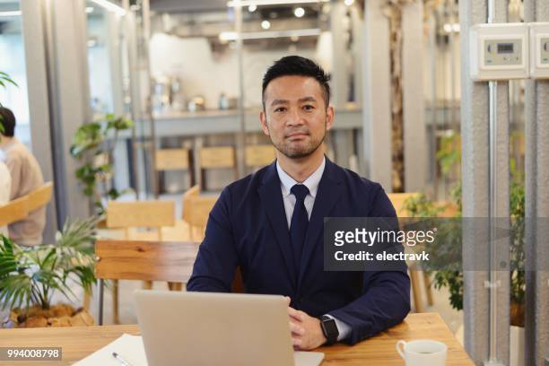 mid adult businessman at coworking lounge - male portrait suit and tie 40 year old stock pictures, royalty-free photos & images