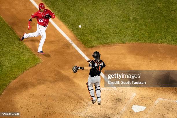 Juan Soto of the Washington Nationals gets past J.T. Realmuto of the Miami Marlins to score during the fifth inning at Nationals Park on July 07,...