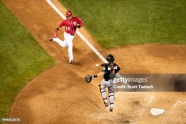 Juan Soto of the Washington Nationals gets past J.T. Realmuto of the Miami Marlins to score during the fifth inning at Nationals Park on July 07,...