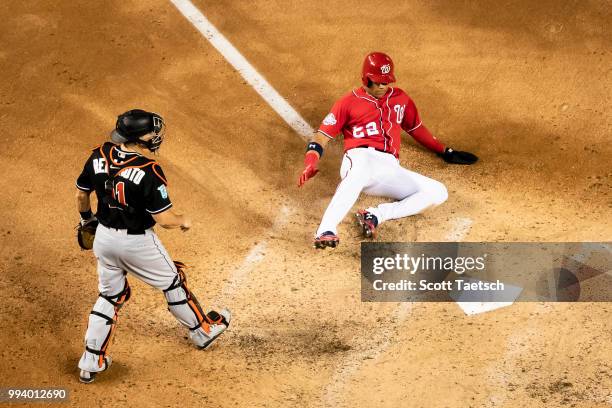 Juan Soto of the Washington Nationals gets past J.T. Realmuto of the Miami Marlins to score during the fifth inning at Nationals Park on July 07,...