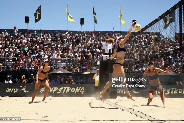 Emily Day goes up to spike the ball as her partner Betsi Flint looks on during their semifinal match against Brittany Howard and Kelly Reeves of the...
