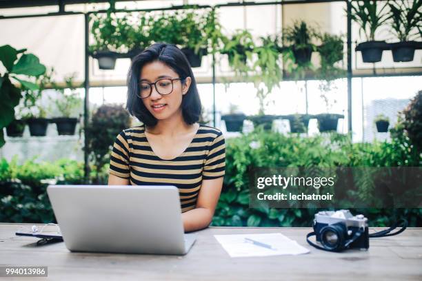 young asian freelancer woman finishing up with work - asian journalist stock pictures, royalty-free photos & images