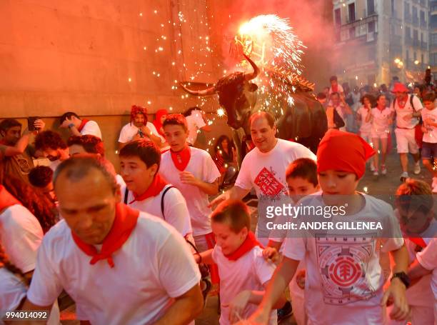 Man wearing a costume of "Toro de Fuego" chases people during the San Fermin Festival on July 8 in Pamplona, northern Spain.