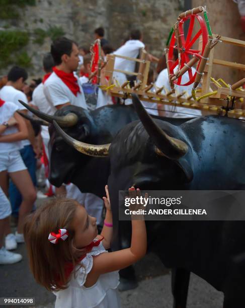 Girl touches a "Toro de Fuego" during the San Fermin Festival on July 8 in Pamplona, northern Spain.