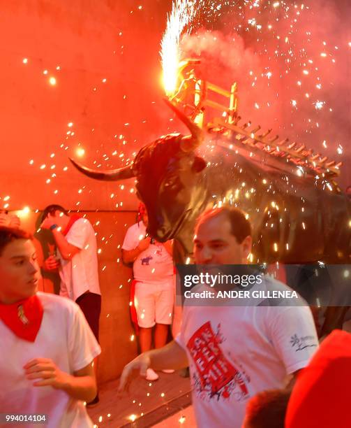 Man wearing a costume of "Toro de Fuego" chases people during the San Fermin Festival on July 8 in Pamplona, northern Spain.