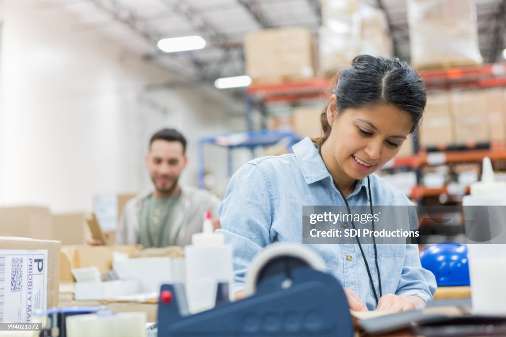 Distribution Associate Woman Concentrates While Working In Distribution Warehouse High-Res ...
