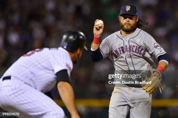 Brandon Crawford of the San Francisco Giants has Nolan Arenado of the Colorado Rockies in a pickle on a run-scoring double play in the seventh inning...