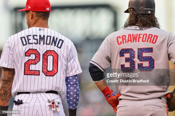Ian Desmond of the Colorado Rockies and Brandon Crawford of the San Francisco Giants stand near first base during a game at Coors Field on July 2,...