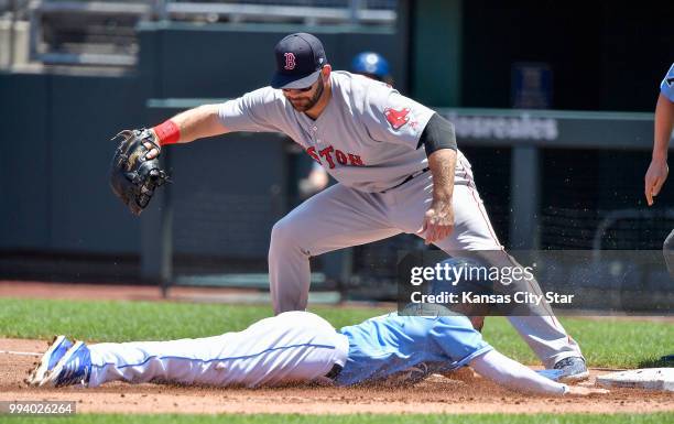 Kansas City Royals' Whit Merrifield gets back to first before the throw to Boston Red Sox first baseman Mitch Moreland on a fly ball out by Jorge...