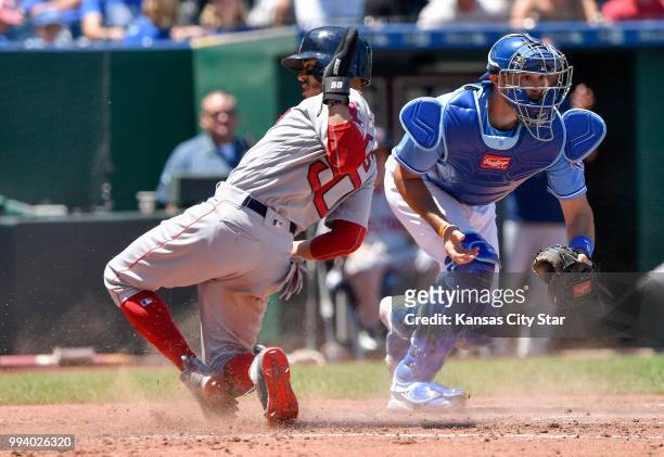 Boston Red Sox's Mookie Betts scores before the tag from Kansas City Royals catcher Drew Butera on a sacrifice fly by Steve Pearce in the third...
