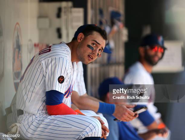 Michael Conforto of the New York Mets watches the ninth inning from the dugout during a game against the Tampa Bay Rays at Citi Field on July 8, 2018...