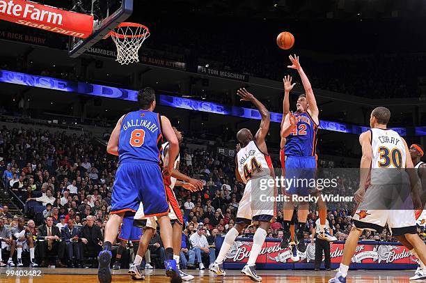 David Lee of the New York Knicks puts up a shot against Anthony Tolliver and Stephen Curry of the Golden State Warriors during the game at Oracle...