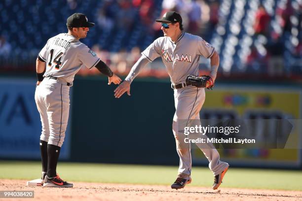 Derek Dietrich of the Miami Marlins celebrates a win with Martin Prado after a baseball game against the Washington Nationals at Nationals Park on...