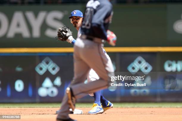 Tyler Saladino of the Milwaukee Brewers turns a double play past Ender Inciarte of the Atlanta Braves in the first inning at Miller Park on July 8,...