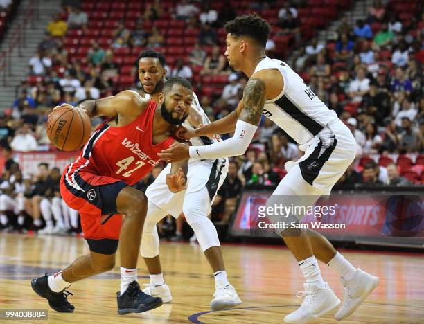 Aaron Harrison of the Washington Wizards drives against Olivier Hanlan of the San Antonio Spurs during the 2018 NBA Summer League at the Thomas &...