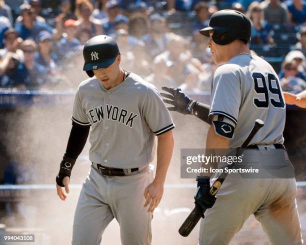 New York Yankees Infielder Tyler Wade gets the go ahead run after sliding home as teammate Outfielder Aaron Judge congratulates him during the MLB...