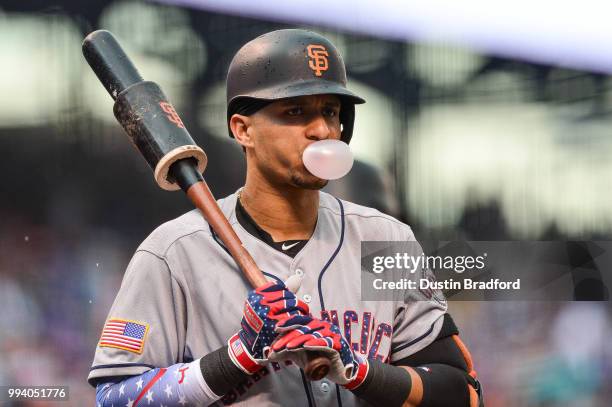 Gorkys Hernandez of the San Francisco Giants blows a gum bubble as he prepares to bat against the Colorado Rockies at Coors Field on July 4, 2018 in...