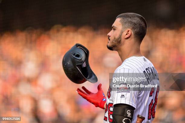 Nolan Arenado of the Colorado Rockies tosses his batting helmet as he stands int he on deck circle before batting against the San Francisco Giants...