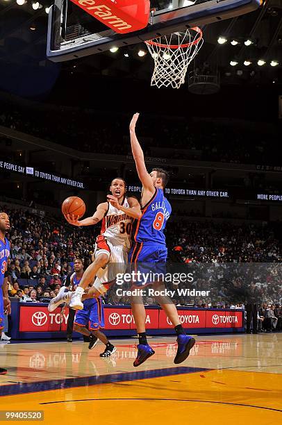 Stephen Curry of the Golden State Warriors goes up for a shot against Danilo Gallinari of the New York Knicks during the game at Oracle Arena on...