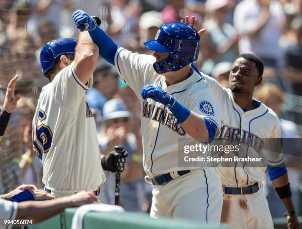 Ryon Healy of the Seattle Mariners is congratulated by David Freitas of the Seattle Mariners and Dee Gordon of the Seattle Mariners after hitting a...