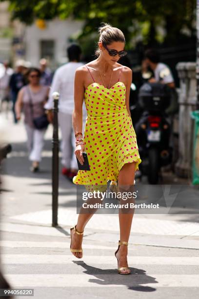 Helena Bordon wears a yellow off-shoulder dress with polka dots, a brown basket bag made of wood, outside Jean-Paul Gaultier, during Paris Fashion...