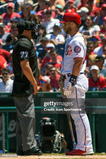 Washington Nationals center fielder Bryce Harper has words with home plate umpire Jim Reynolds after being called out on strikes to end the first...